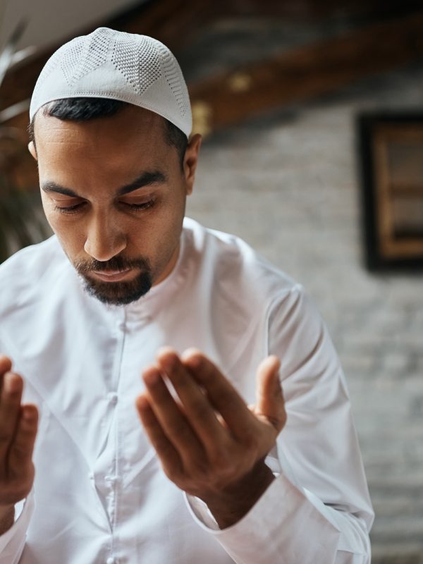 Mid adult man of Islam faith praying at home.