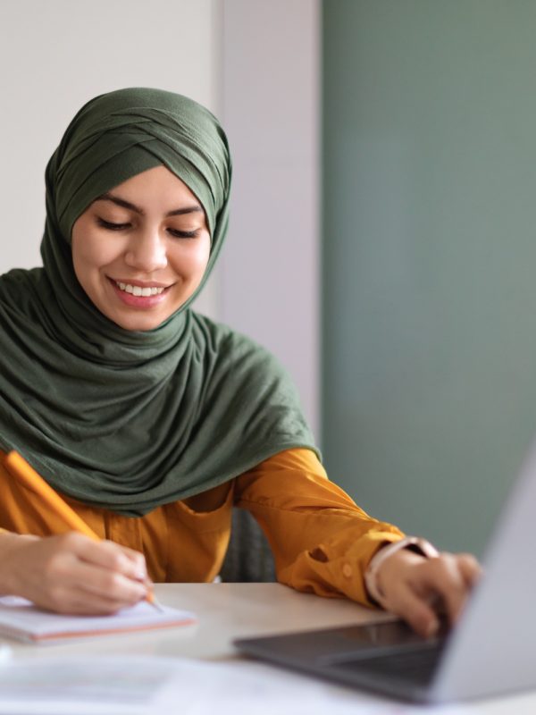 Online Education. Smiling Muslim Woman In Hijab Study With Laptop At Home