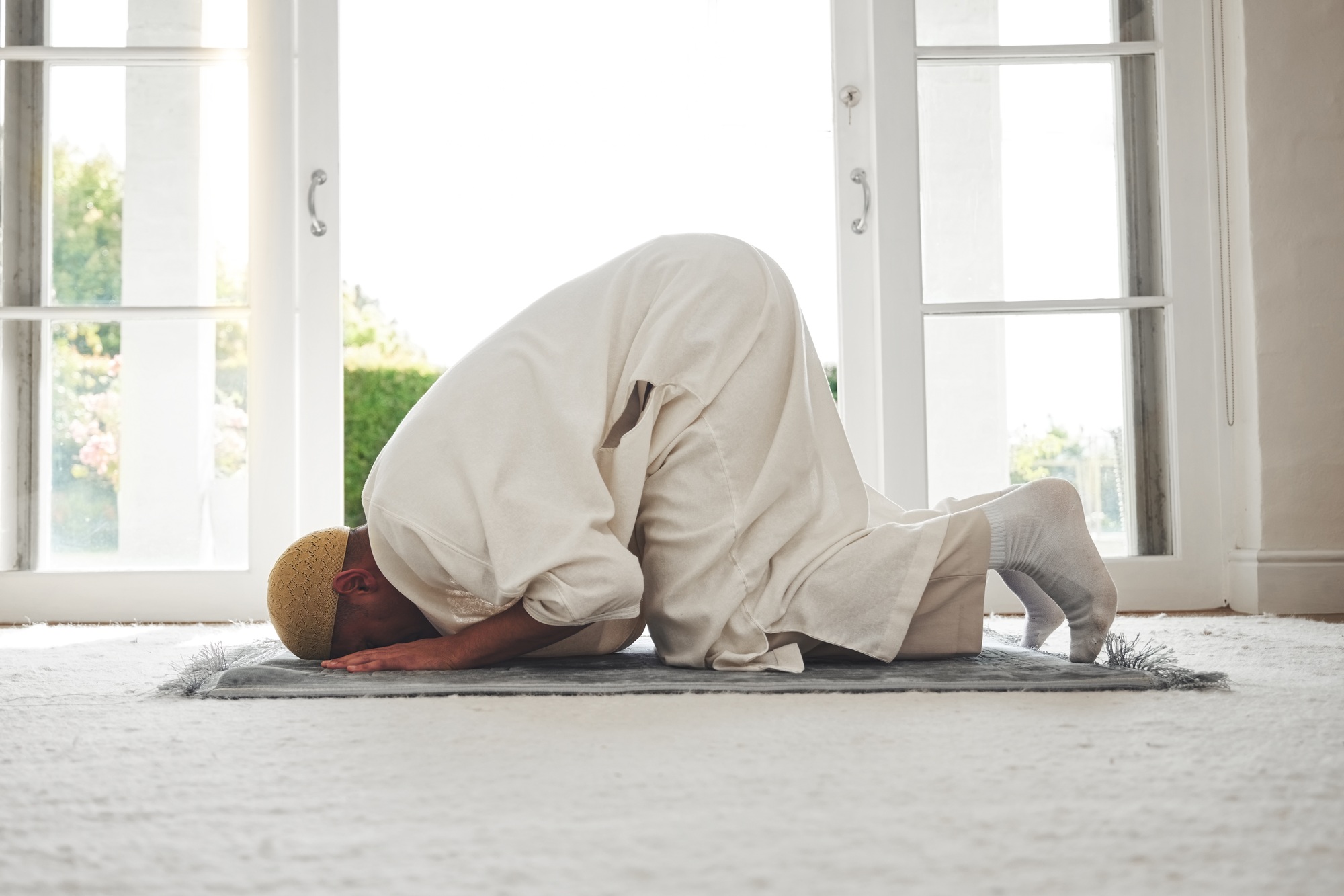 Prayer, muslim and islamic with man on living room floor for eid mubarak, God and worship. Quran, h
