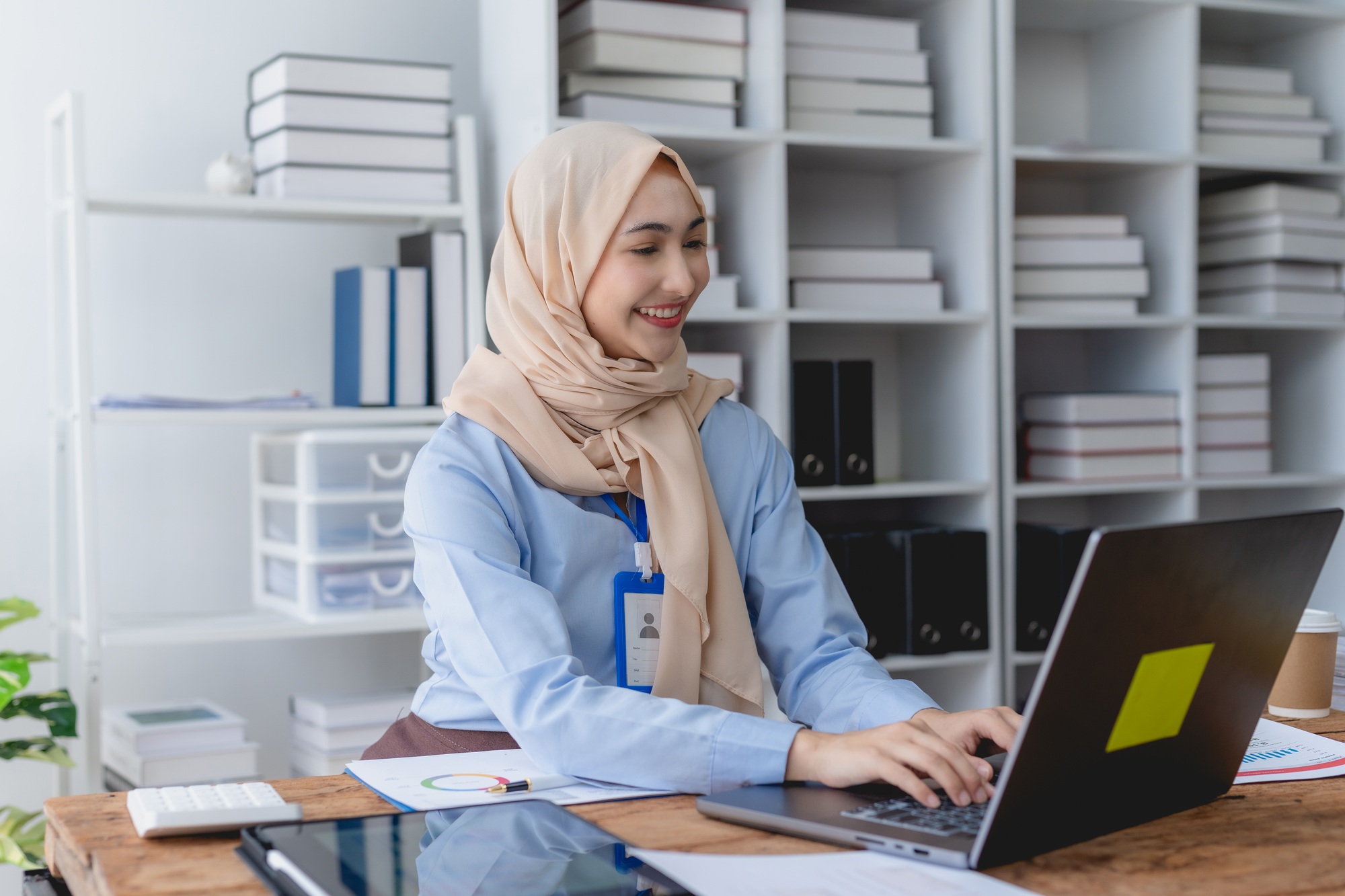 Muslim businesswoman sit at her desk with a laptop and document in the office
