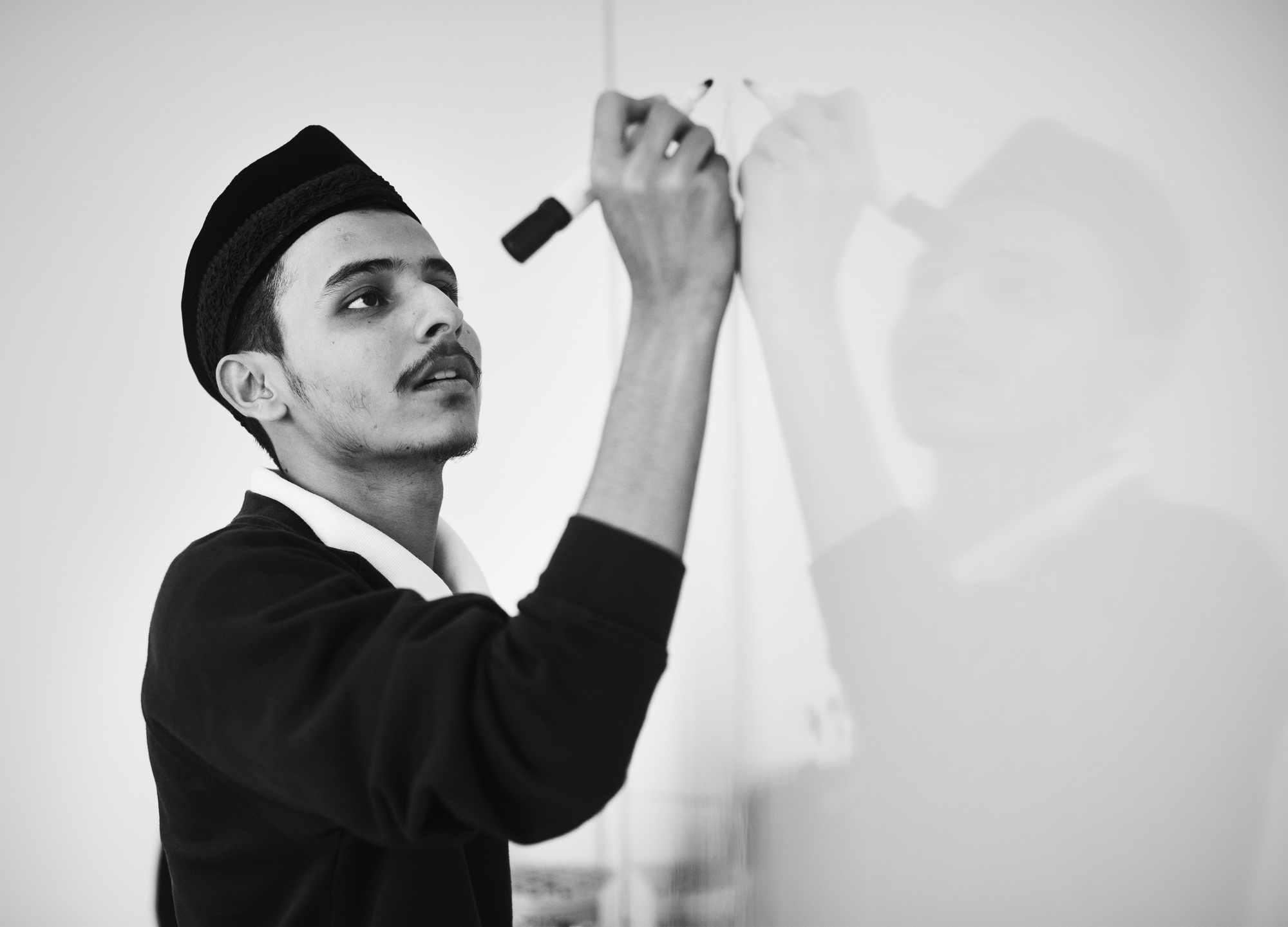 Young muslim man is writing a white board