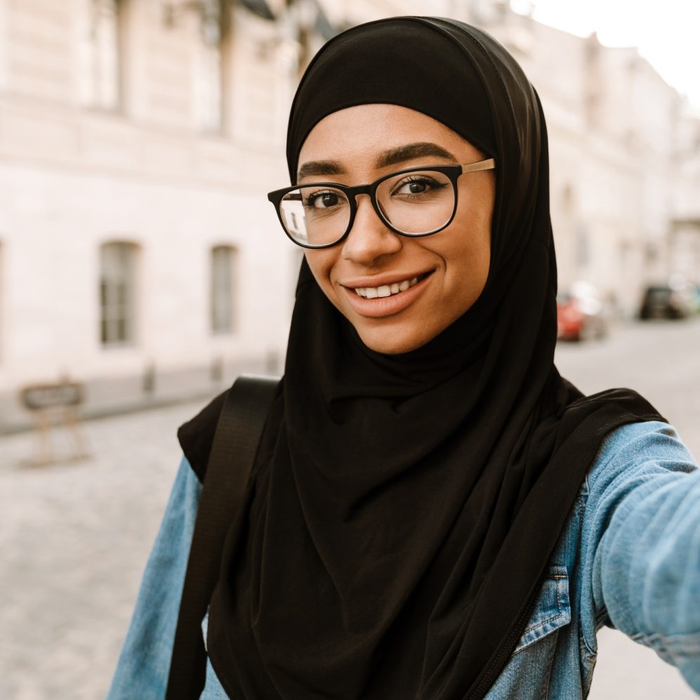 Young muslim woman wearing hijab smiling while taking selfie photo