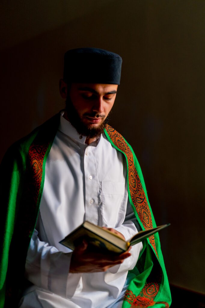 Islamic prayer concept Close-up of a Muslim man sitting on his knees praying with the Holy Quran