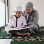 Father teaching son reading Al Qur'an