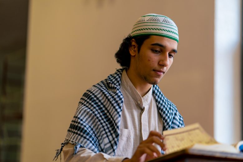 a-muslim-prays-in-the-holy-mosque-with-the-help-of-the-koran-alone-and-asks-allah-to-help-him