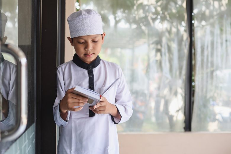 asian-muslim-boy-is-standing-and-reading-the-holy-quran