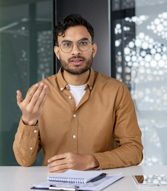 serious-man-in-office-looking-at-camera-while-explaining-during-business-meeting