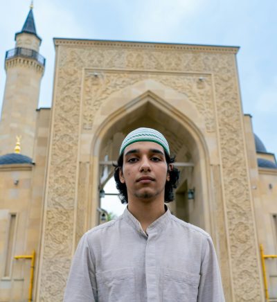 man-of-muslim-appearance-leaving-the-mosque-after-prayer-on-a-terrace-with-islamic-ornaments