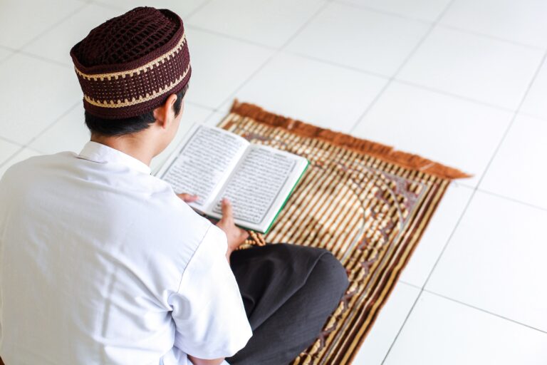 muslim-man-reading-holy-quran-on-prayer-mat