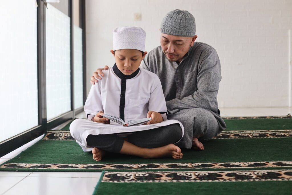 Father teaching son reading Al Qur'an