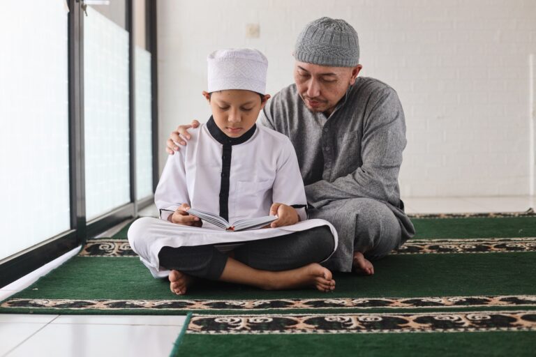 Father teaching son reading Al Qur'an