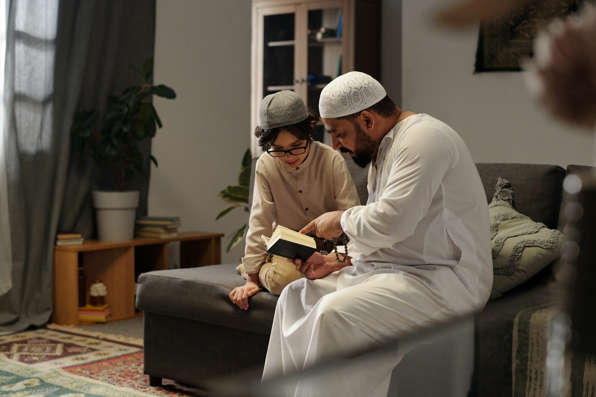 Muslim Man Reading Quran To His Son