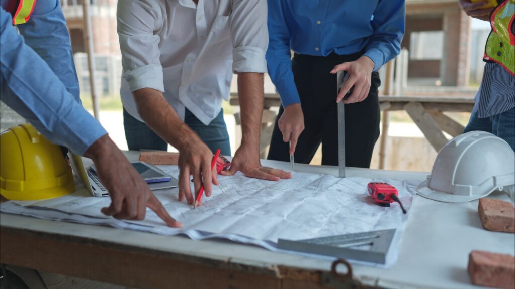 Group of architects and engineers work together to assess the residential home construction site