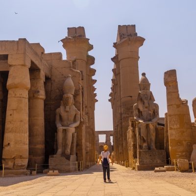 woman-tourist-with-a-hat-visiting-the-egyptian-temple-of-luxor-and-its-beautiful-columns