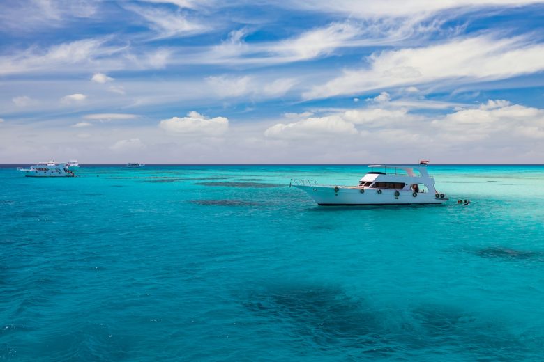 Cruise yacht bow in clear water near a coral reef. Red Sea, Egypt